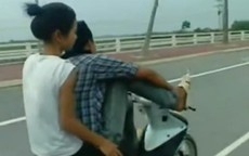 Thanh niên lái xe bằng chân chở bạn gái